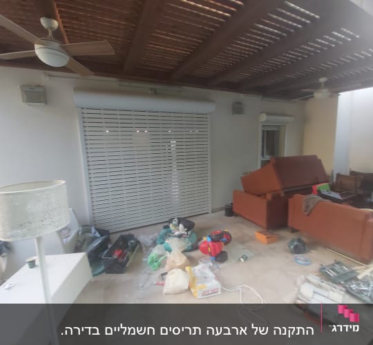 מרפסת עם תריסי אלומיניום סגורים וכלי עבודה על הרצפה